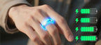 Hand trägt leuchtenden Onevik Smart Ring mit Batteriesymbol-Grafiken vor unscharfem Hintergrund