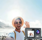 Mann macht Selfie mit Swevix Action Kamera, Videowiedergabe auf Display vor Bergkulisse