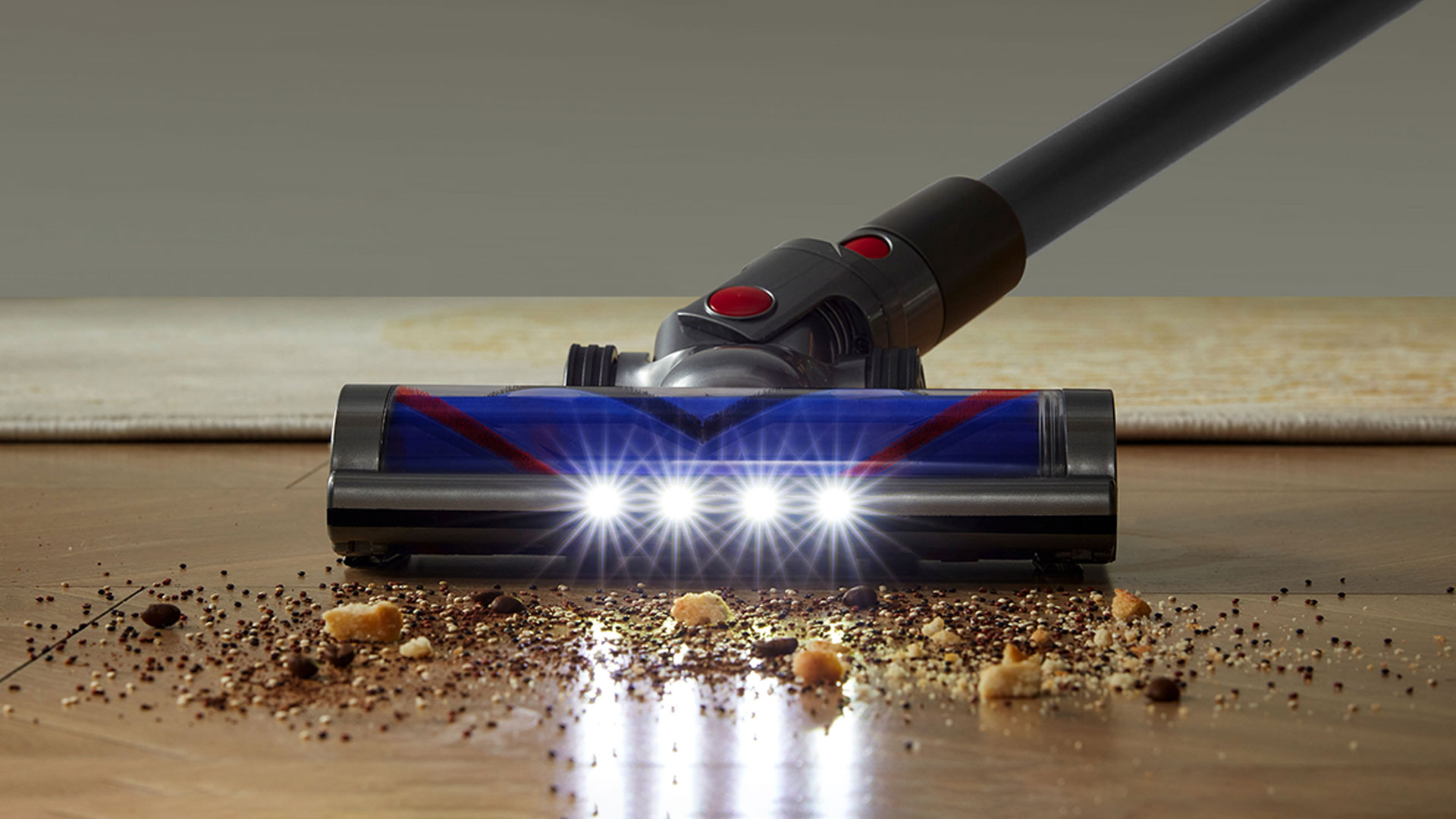 StarPod Staubsaugerkopf reinigt einen Holzboden, darunter sind die Zubehörteile dargestellt