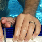 Nahaufnahme von Händen mit blauem Poolnudel und Wassertropfen auf der Haut vor blauem Poolhintergrund